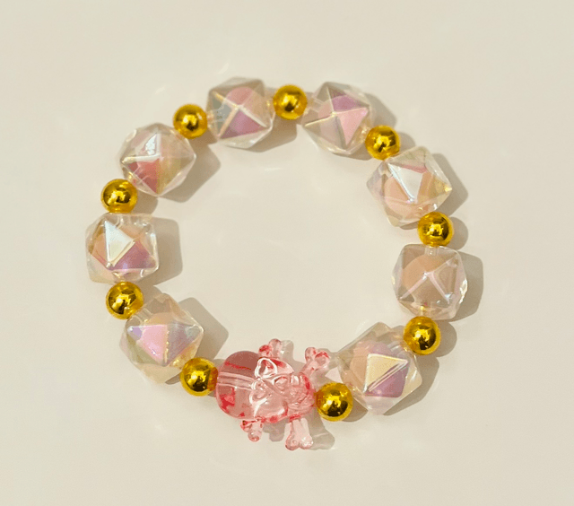 Roze Crystal Skull Charm armband – handgemaakte stretcharmband met iriserende kralen, gouden accenten en roze skull bedel 